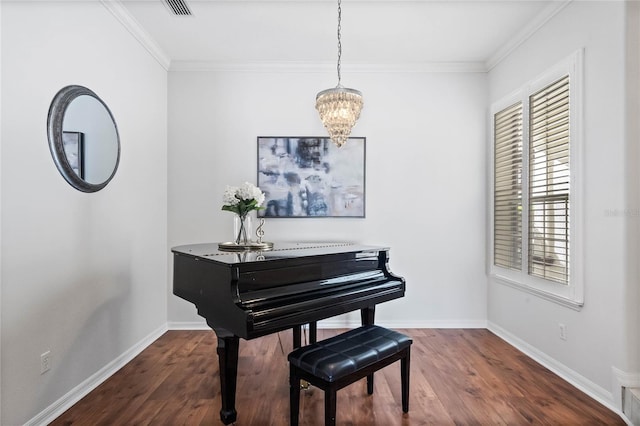 misc room featuring dark hardwood / wood-style floors, crown molding, a notable chandelier, and a healthy amount of sunlight