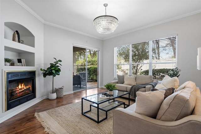 living room with a notable chandelier, crown molding, and dark wood-type flooring