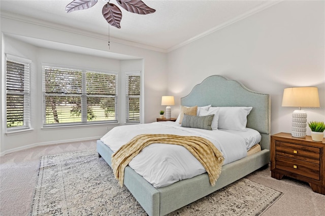 carpeted bedroom with ceiling fan and ornamental molding