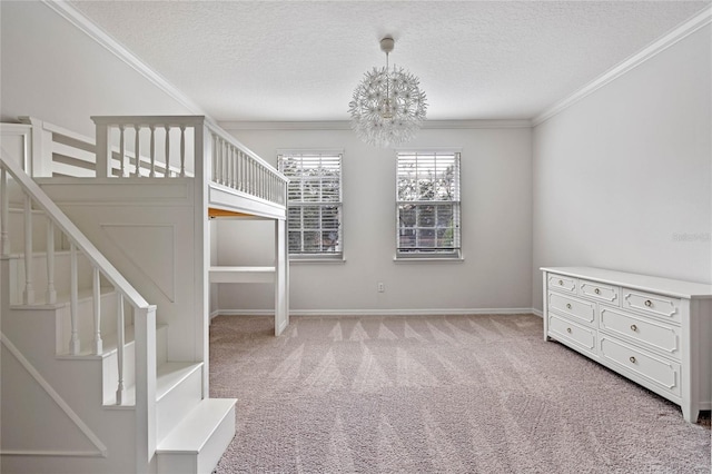 interior space with a textured ceiling, a chandelier, carpet floors, and ornamental molding