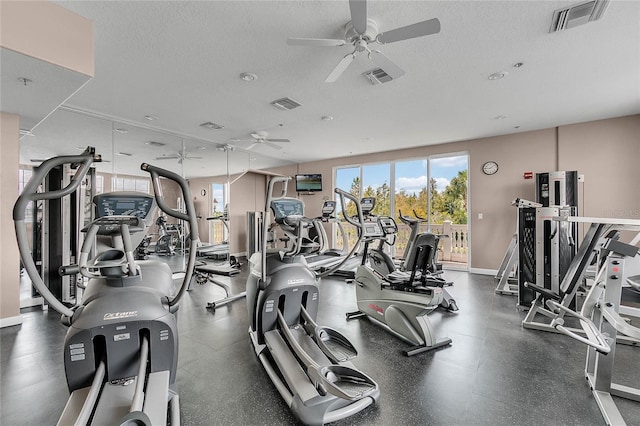 gym with ceiling fan and a textured ceiling