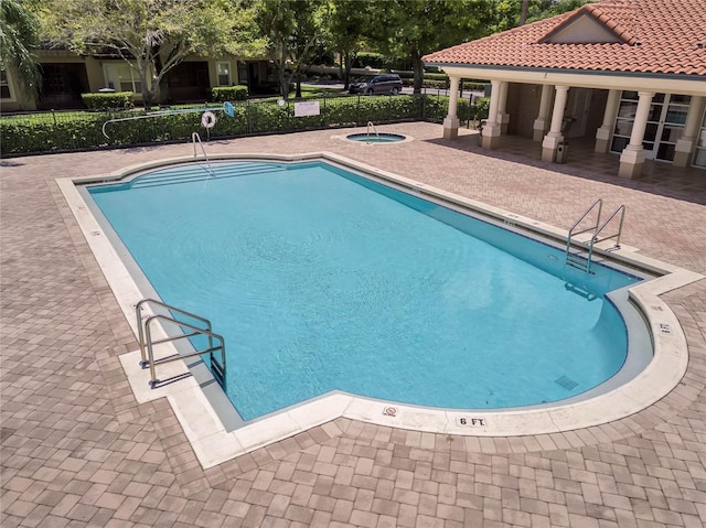 view of pool featuring a community hot tub and a patio