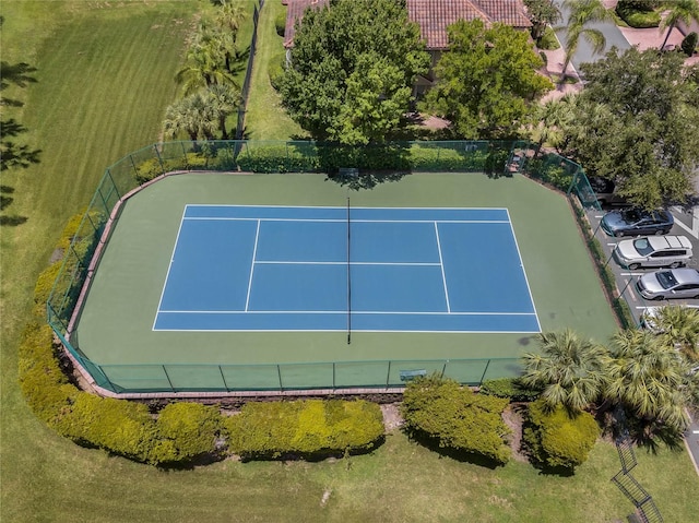 view of tennis court featuring a lawn