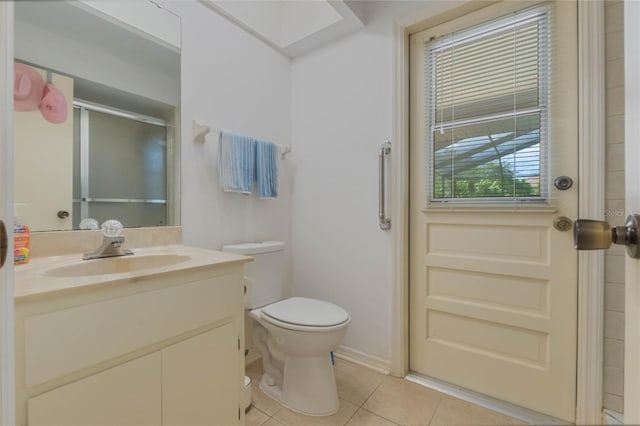 bathroom featuring toilet, vanity, an enclosed shower, and tile patterned flooring