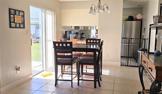 dining space with light tile patterned floors and an inviting chandelier