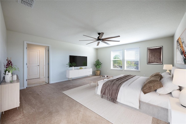 carpeted bedroom with a textured ceiling and ceiling fan