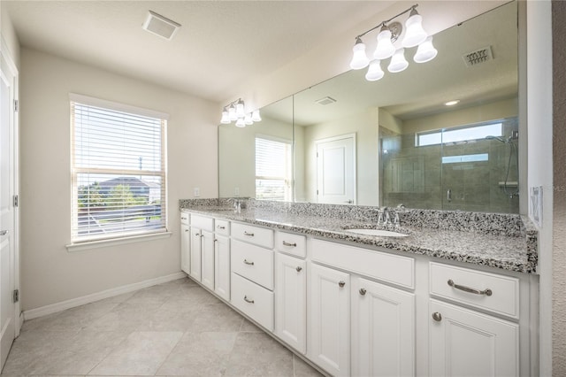 bathroom with a wealth of natural light, vanity, a shower with shower door, and a textured ceiling