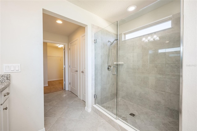 bathroom featuring tile patterned flooring, vanity, and walk in shower