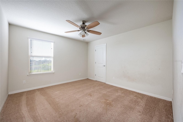 carpeted empty room with ceiling fan and a textured ceiling