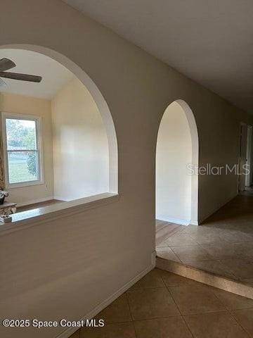 hallway featuring dark tile patterned floors