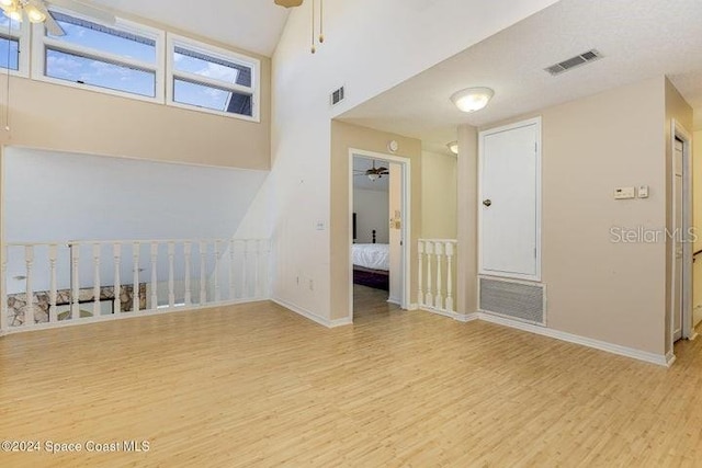 empty room with ceiling fan and light wood-type flooring