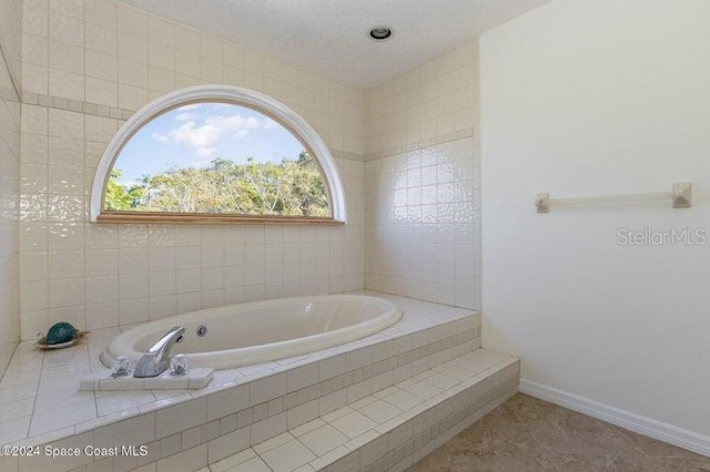 bathroom featuring a relaxing tiled tub and tile patterned floors