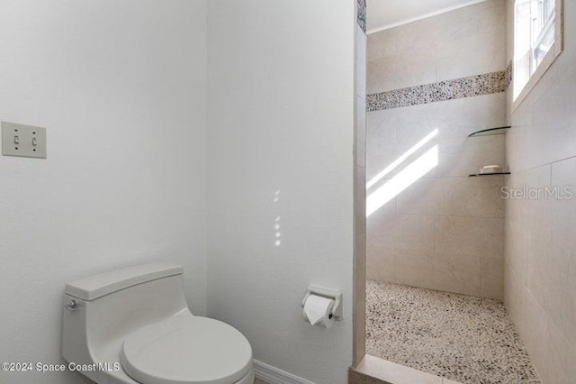 bathroom with tiled shower and toilet