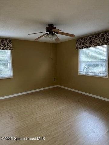 unfurnished room with hardwood / wood-style flooring and ceiling fan