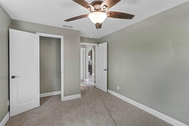 unfurnished bedroom with light colored carpet and ceiling fan