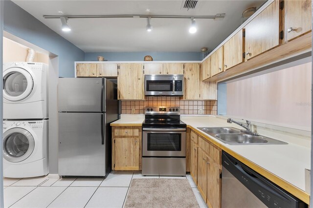5208 Via Hacienda Cir Unit 201, Orlando, FL 32839 - kitchen with stainless steel appliances, stacked washer and clothes dryer, track lighting, a sink, and light countertops