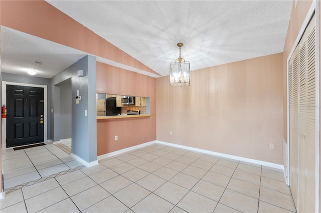 unfurnished dining area featuring a textured ceiling, light tile patterned floors, an inviting chandelier, and vaulted ceiling