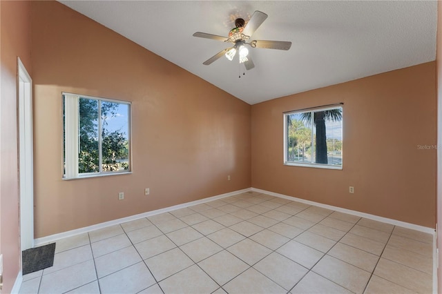 tiled empty room with ceiling fan, lofted ceiling, a textured ceiling, and a healthy amount of sunlight