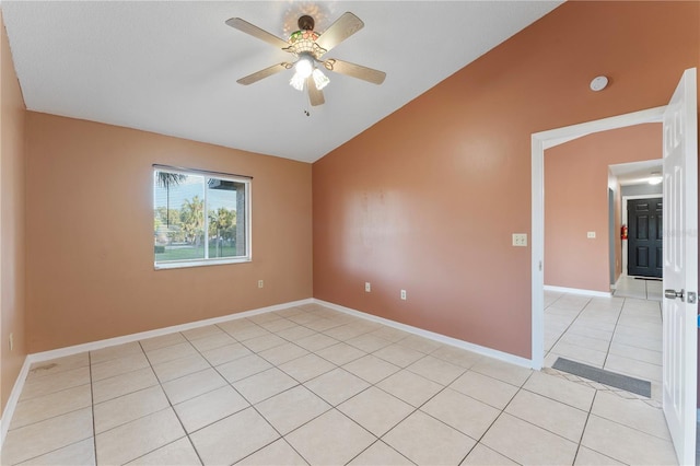 empty room featuring vaulted ceiling, light tile patterned floors, and ceiling fan