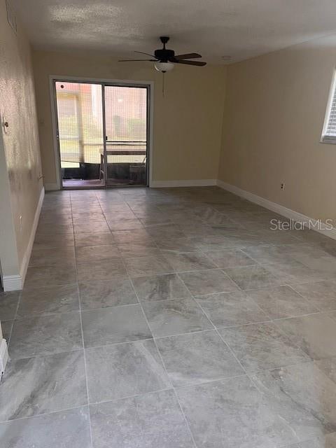 empty room featuring a textured ceiling and ceiling fan