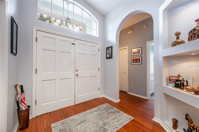 foyer with dark hardwood / wood-style flooring and high vaulted ceiling