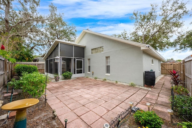 back of property with a patio area and a sunroom