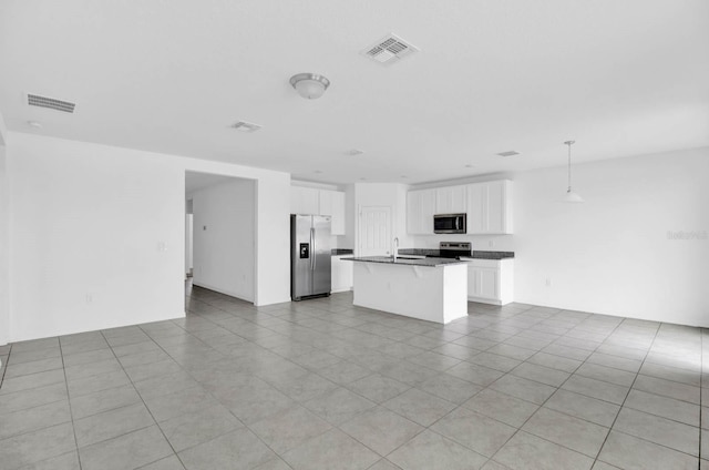 kitchen featuring appliances with stainless steel finishes, sink, decorative light fixtures, white cabinetry, and an island with sink