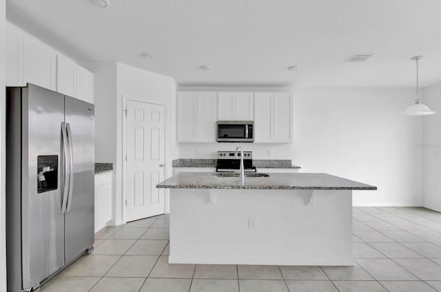 kitchen featuring appliances with stainless steel finishes, white cabinetry, a kitchen island with sink, and sink