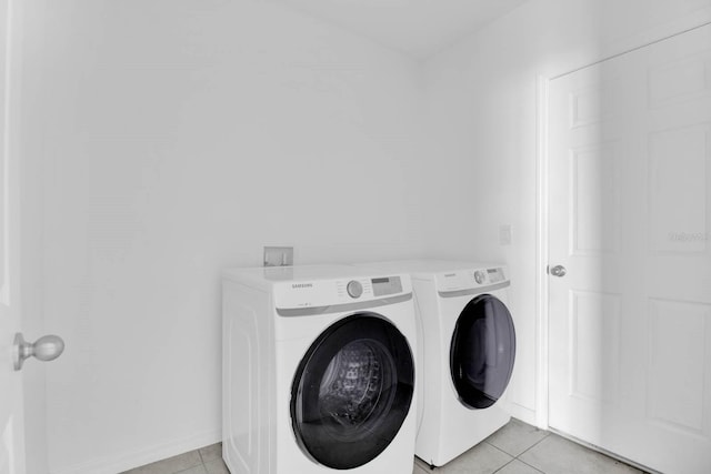 laundry area featuring light tile patterned flooring and washing machine and dryer