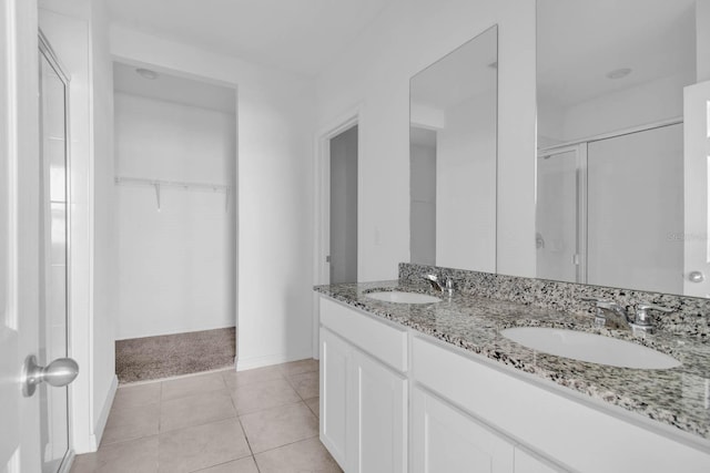 bathroom featuring tile patterned flooring, vanity, and walk in shower