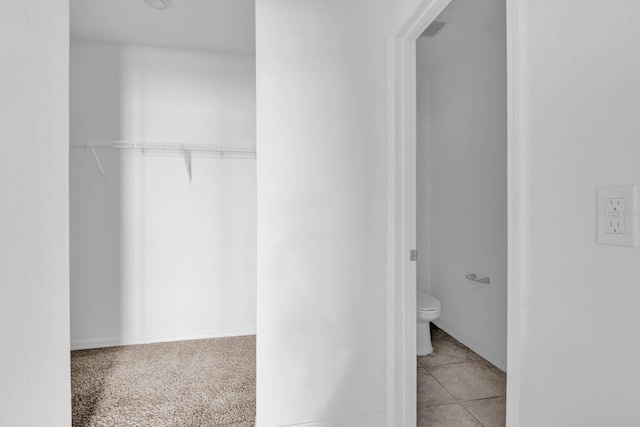 interior space featuring tile patterned flooring and toilet