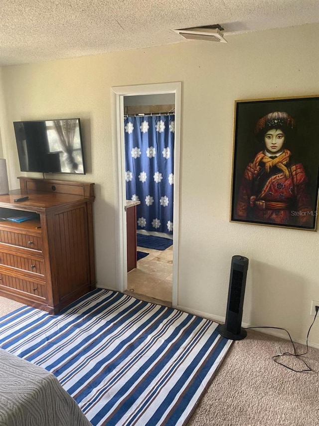 bedroom featuring light carpet and a textured ceiling