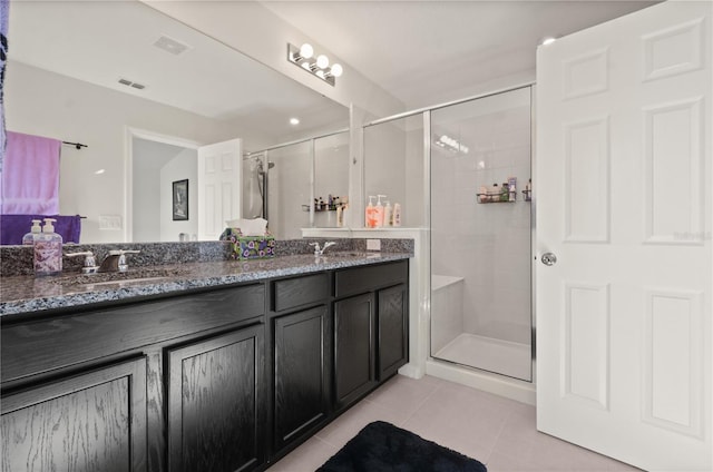 bathroom featuring tile patterned flooring, vanity, and walk in shower