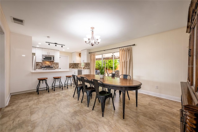 dining area featuring wooden walls and a chandelier