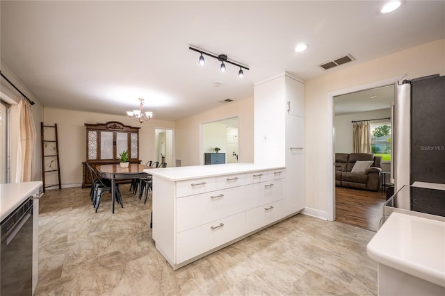 kitchen with black dishwasher, kitchen peninsula, pendant lighting, a chandelier, and white cabinets