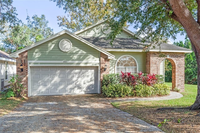 view of front of home with a garage and central AC