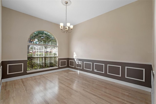 unfurnished room with light hardwood / wood-style floors and a chandelier