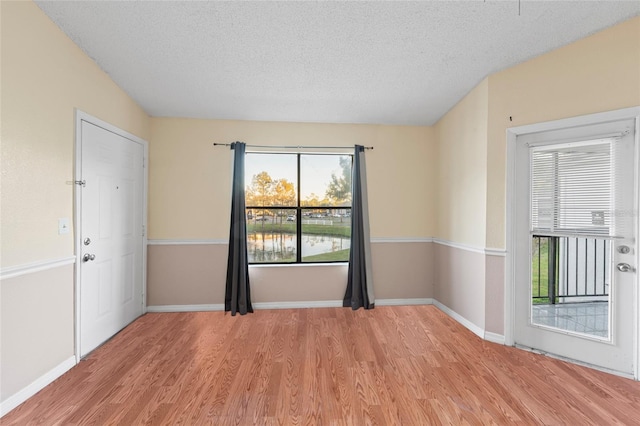 empty room featuring a textured ceiling and light wood-type flooring