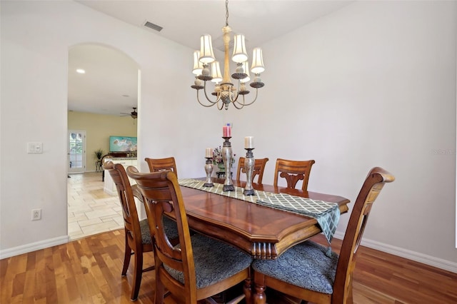 dining area featuring hardwood / wood-style floors and ceiling fan with notable chandelier