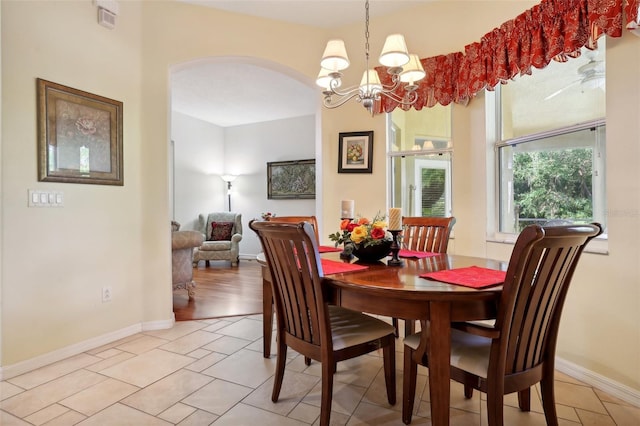 dining area with a chandelier and light tile patterned flooring