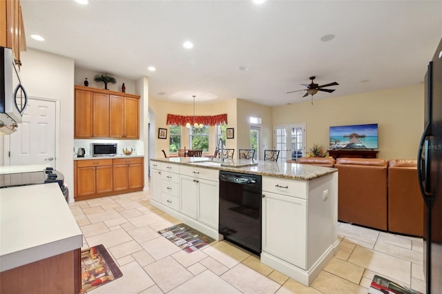 kitchen featuring black appliances, ceiling fan, white cabinetry, decorative light fixtures, and an island with sink