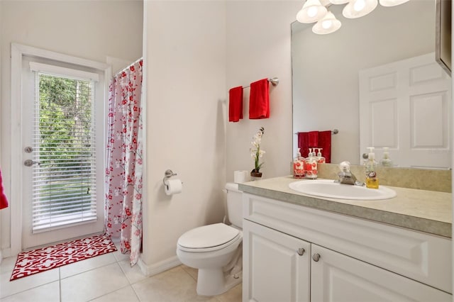 bathroom with toilet, vanity, and tile patterned flooring