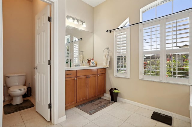 bathroom with tile patterned floors, vanity, toilet, and a healthy amount of sunlight