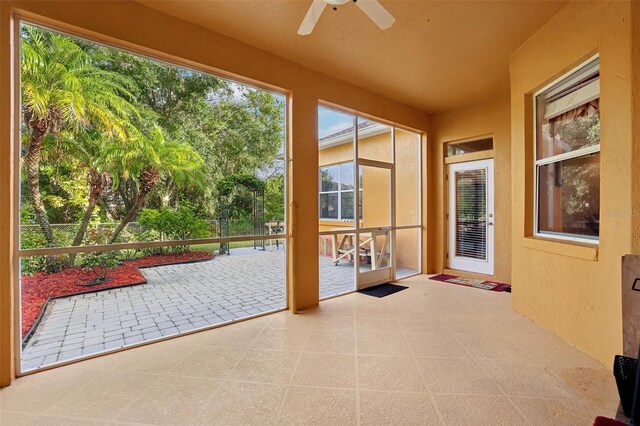 unfurnished sunroom with ceiling fan