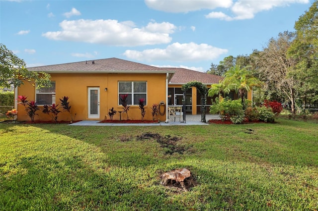 back of property featuring a patio area and a yard