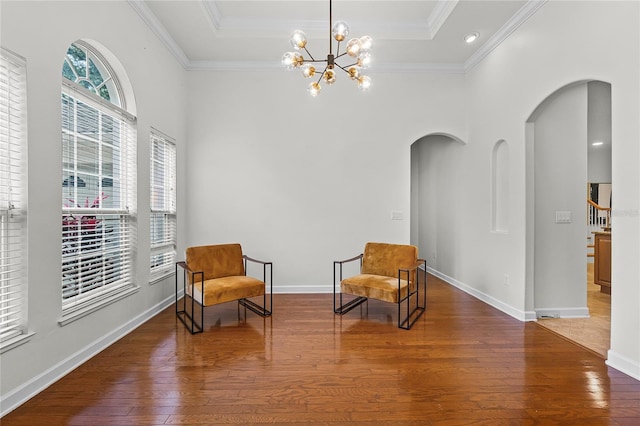 sitting room featuring crown molding, dark wood-type flooring, and an inviting chandelier