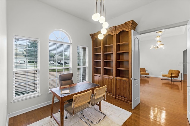 office with a notable chandelier and light hardwood / wood-style flooring