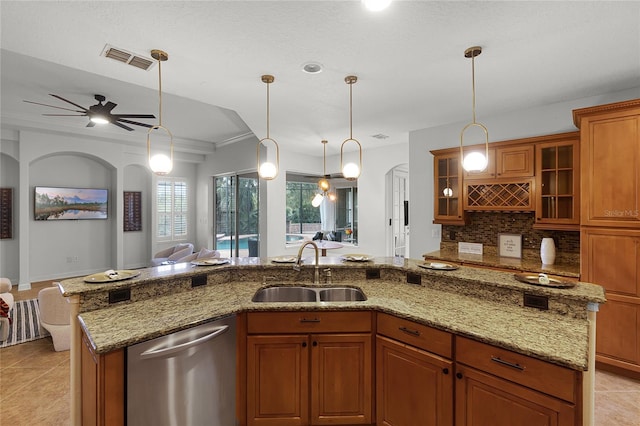 kitchen with dishwasher, a kitchen island with sink, ceiling fan, and sink