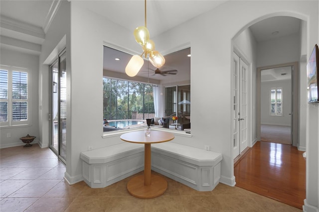 interior space featuring plenty of natural light, crown molding, and light tile patterned flooring