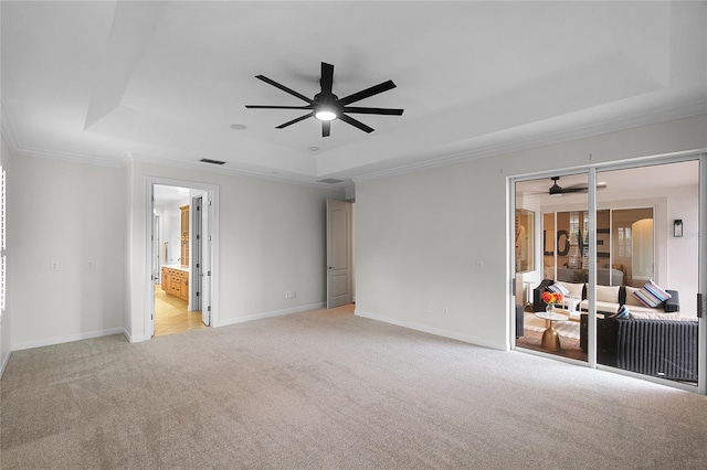 carpeted spare room featuring ceiling fan, a raised ceiling, and crown molding